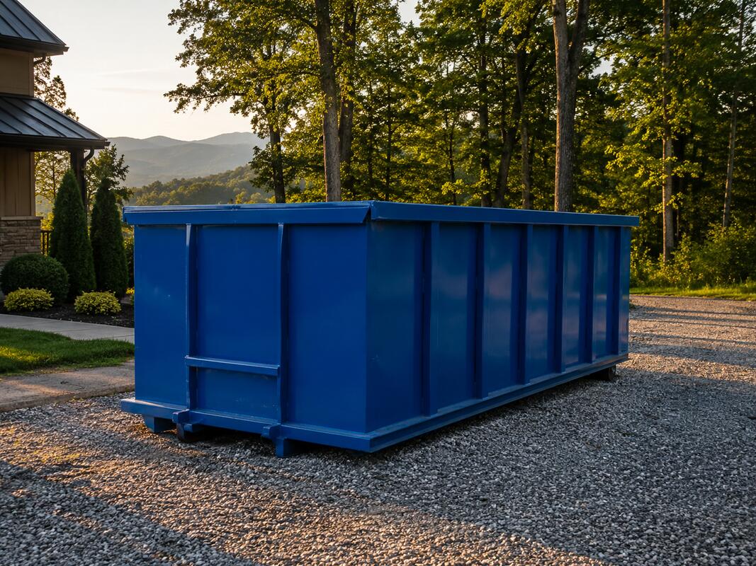 Blue roll-off dumpster on residential driveway in Boone NC with Appalachian mountain scenery